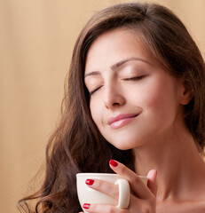 Beautiful woman holding a cup of coffee. Aroma of coffee - 541461366