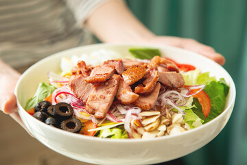 person holding a bowl of salad