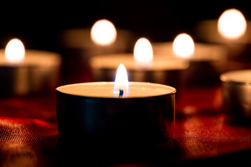 Candle light and red fabric background in the darkness with space for text or image. valentine love concept