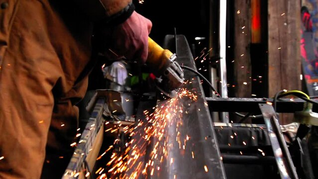 Slow Motion Shot Of Welder Using Angle Grinder On Metal In Workshop - Yellowstone Park, Montana