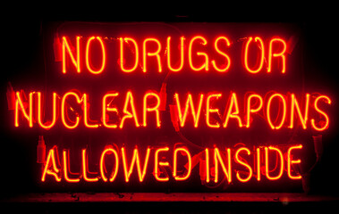 orange neon sign with words, no drugs or nuclear weapon allowed inside