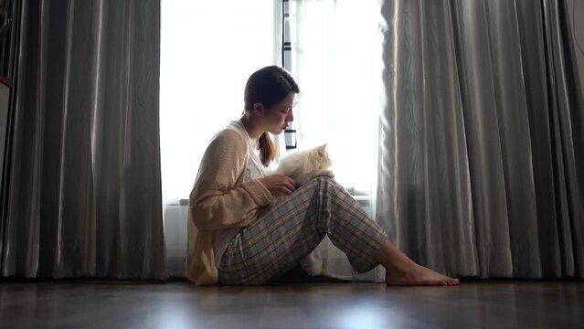 woman sit Depression Dark haired  pensive glance and holding cat Standing by window and anxiety Copy space.