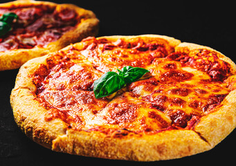 sliced Pizza with Mozzarella cheese, Tomatoes, pepper, Spices. Italian pizza. Pizza Margherita or Margarita on Dark grey black slate background