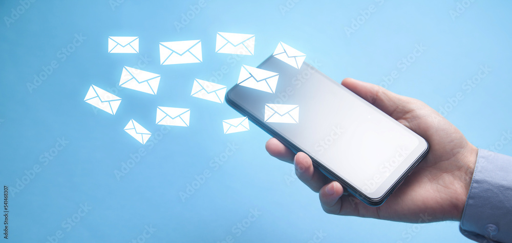 Wall mural man sending email by smartphone.