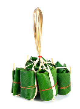 Bunch of sour pork in banana leaf wrapping isolated on white background. Raw fermented sour pork preservation in green banana leaves with package.