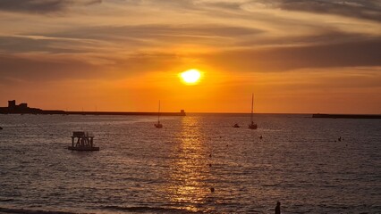 Naklejka na ściany i meble beautiful sunset on the coast over the sea. sunset from the beach.