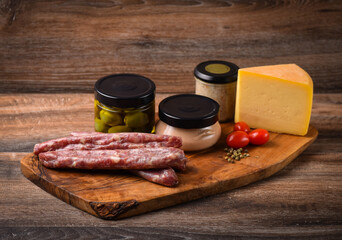 A plateau with appetizers of meat and cheese delicacies, olives, pates.