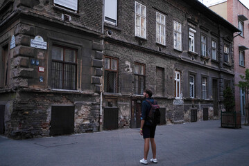 Tourist looking at an old crumbling poor building in the city