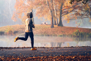 man jogs in park on autumn morning
