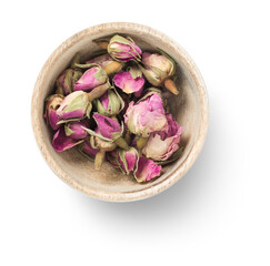 small pink dry / dried rosebuds in a wooden bowl, isolated, flat lay / top view with a subtle shadow