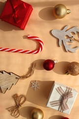 Small presents and various Christmas ornaments on neutral background. Top view.