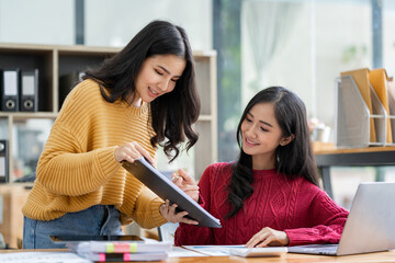 Asian female sales representatives in the section of Real estate talked and discussed tax plans to search for information Ask questions and give advice. All information is recorded and detailed.