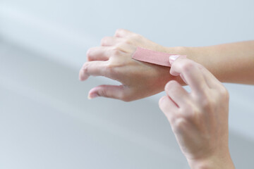 hand putting Adhesive Bandage. band-aid on a cut. isolated on white