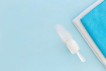 Flatlay of laundry detergents powder with fresh towels