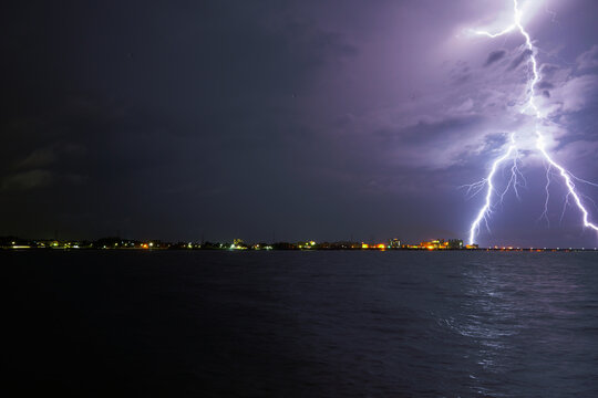 Thunderstorm with lightning in the port city by the sea