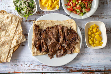 Turkish meat doner on wood background. Traditional flavors. Doner kebab made from beef and lamb....