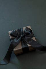 Black Friday Sale concept. Gift box with black ribbon isolated on black.