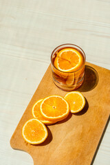 Oranges sliced on a wooden surface in the light of the sun.