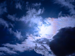 Obraz premium The sun shines through overcast dark-blue clouds