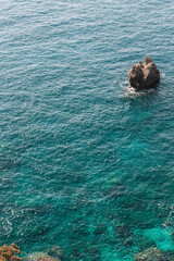 Corfu, Greece. Top view of blue water with a lonely rock.