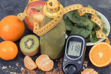 Glucometer for checking sugar level, freshly blended coctail from fruits and vegetables and...