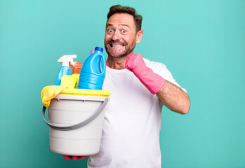 middle age man feeling happy and facing a challenge or celebrating. housekeeper with clean products