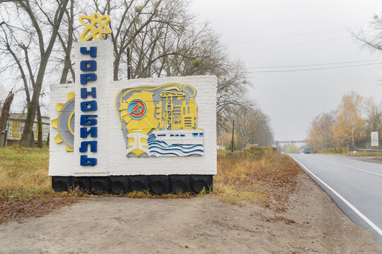 Chernobyl town lettering sign entrance near to a road with cloudy sky at background