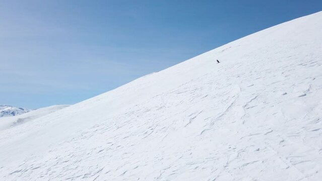 Experienced skier skiing on slope. Sunny day and clear blue sky. Recorded at 60fps.