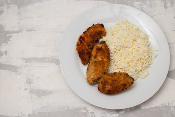 Delicious crispy fried breaded chicken breast strips with boiled rice