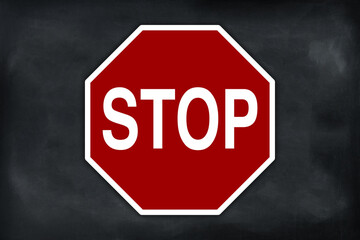 Red color stop sign on black chalkboard with empty space for text around.