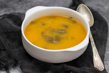 vegetable soup with crackers in white bowl on ceramic
