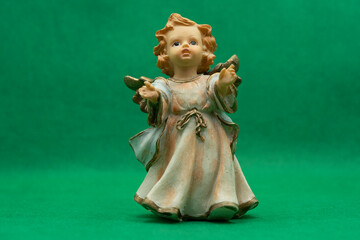 Naklejka premium Angel figurine close-up on a green background