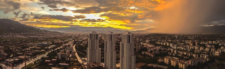 Aerial panoramic view of Skopje cityscape during colorful cloudy sunset in Macedonia