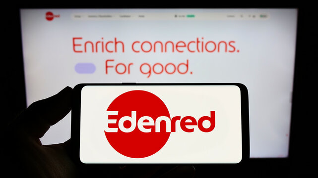 Stuttgart, Germany - 10-23-2022: Person holding smartphone with logo of French payment solutions company Edenred SE on screen in front of website. Focus on phone display.