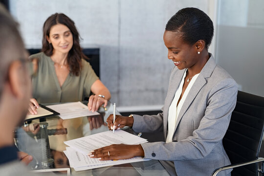 African businesswoman signing document during meeting