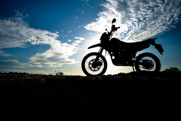Obraz na płótnie Canvas Beautiful evening motocross motorcycle silhouette on the mountain