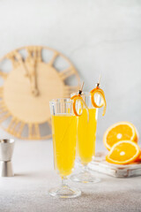 Festive Alcohol cocktail Mimosa with Orange juice and cold Champagne or sparkling Wine in glasses on table.