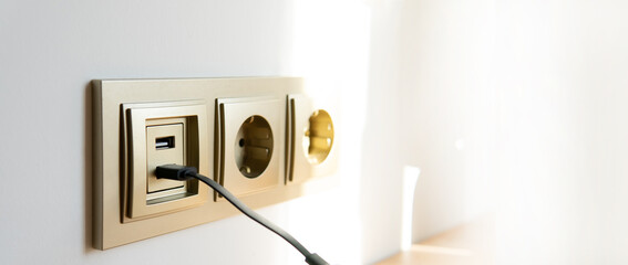 usb charging built into the wall with a wire. wired device charging via usb. charger cord close-up...