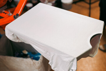 white t-shirt is ready for printing. creating print on t-shirt in workshop. serigraphy production....