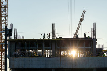 Builder workers working on construction site and sunset,beam, steel structure.Workers build large...