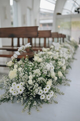 Wedding ceremony in the chapel for intimacy family and friends. Sunny outdoors afternoon natural light. Flowers arrangement for decoration details.