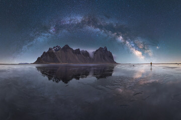 Picturesque scenery of sea and mountains on bright starry sky in dusk