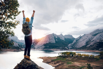 Traveler standing on rocky formation near lake