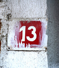 House number 13 on red metal plate enameled