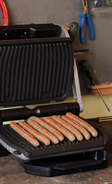 Fried Sausages On The Grill In The Garage