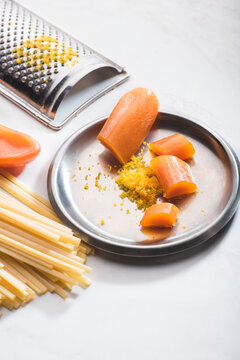 Bottarga, dried roe of mullet or tuna eggs, &nbsp;with grater&nbsp; and pasta on the white background.  Sardinian  and Sicilian recipe. Pasta with bottarga