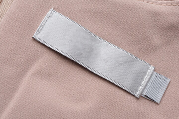 Blank laundry care clothes label on fabric texture background