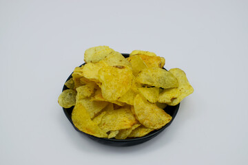 Popular potato chips in black plate isolated on white background