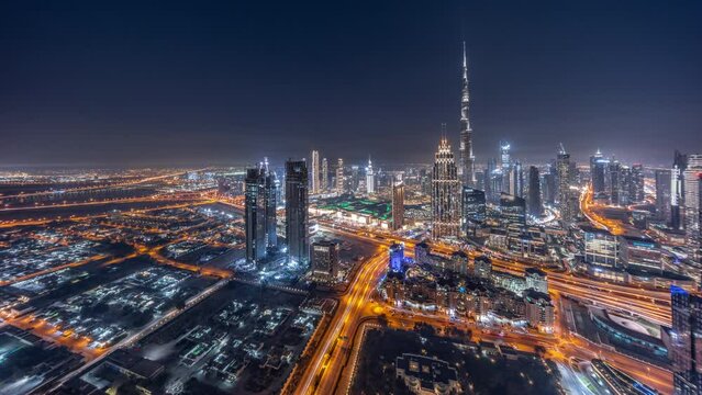 Aerial view of tallest towers in Dubai Downtown skyline and creek area day to night transition timelapse. Financial district and business area in smart urban city. Skyscraper and high-rise buildings
