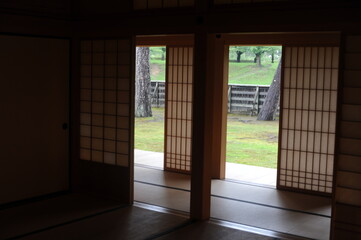 Interior of Japanese style rom with sliding door and windows with paper walls and wooden frames